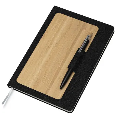 Caderno de anotações com suporte para caneta, capa dura em material reciclável e bambu, miolo com 80 folhas pautadas na cor bege. NÃO ACOMPANHA CANETA.